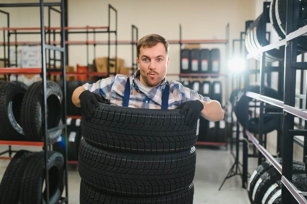 Funny tire shop employee having fun at work with tire speed ratings explained.