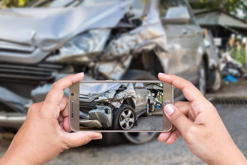 hands taking a picture of a hit and run accident with a smartphone