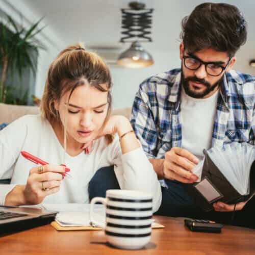 young couple filing 2020 taxes on their living room