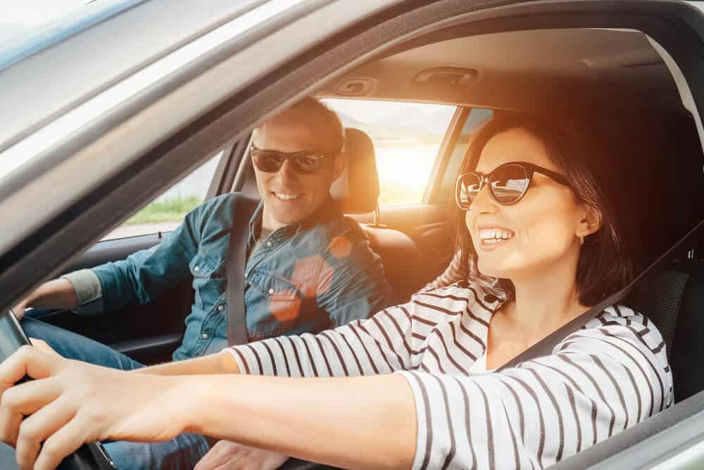 smiling woman and man in borrowed car