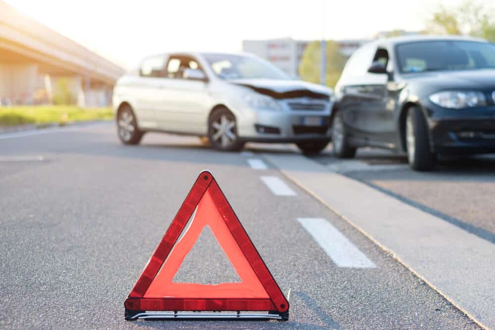 traffic sign on the road with a car accident on the backgroud