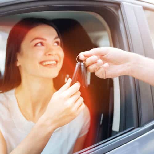 woman in car taking car keys from another person