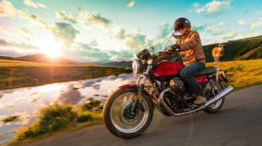 side view of a motorcycle rider on the road during a sunset