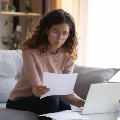 hispanic woman looking at car insurance policy terms