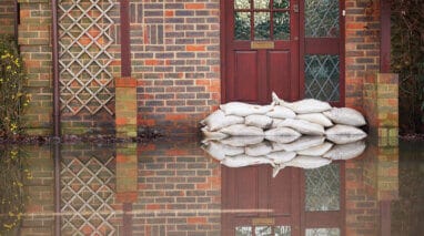 front view of front door of flooded house with sand bags