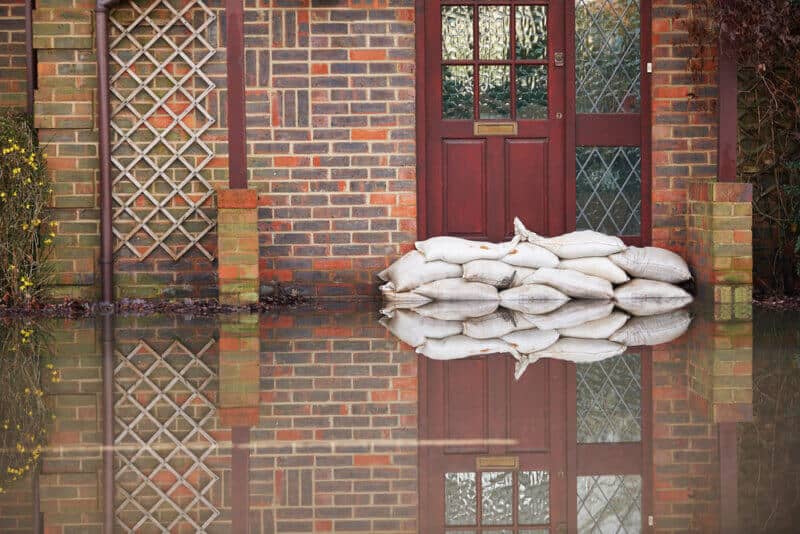 front view of front door of flooded house with sand bags