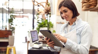 female business owner in shop looking at tablet