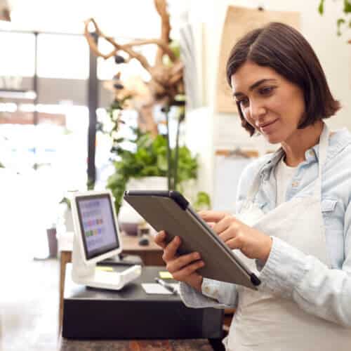 female business owner in shop looking at tablet