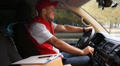 delivery man in commercial auto with boxes and insurance