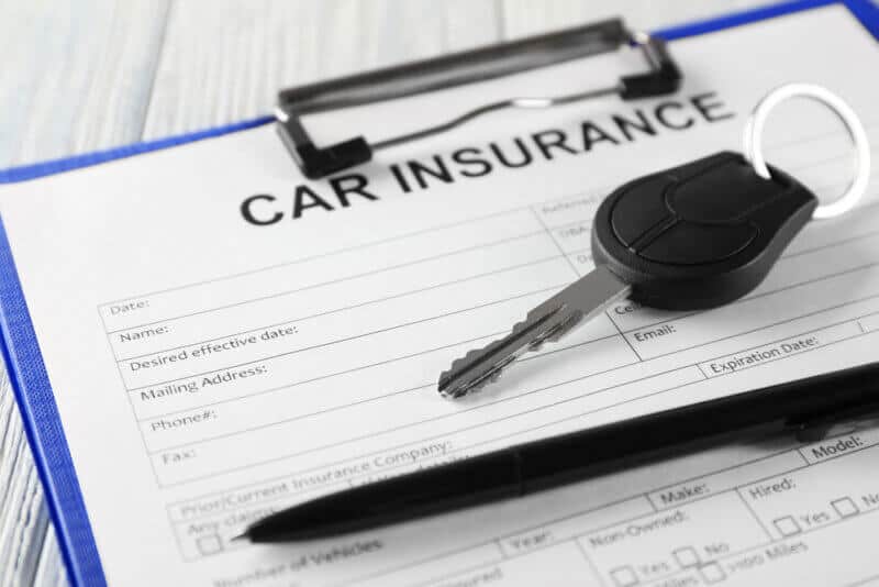 Car,Insurance,Form,And,Key,On,Table clipboard with auto insurance form and car keys