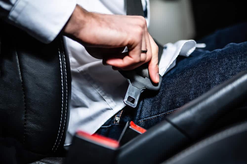 caucasian man buckling his seatbelt in the car