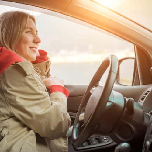 woman in coat driving car