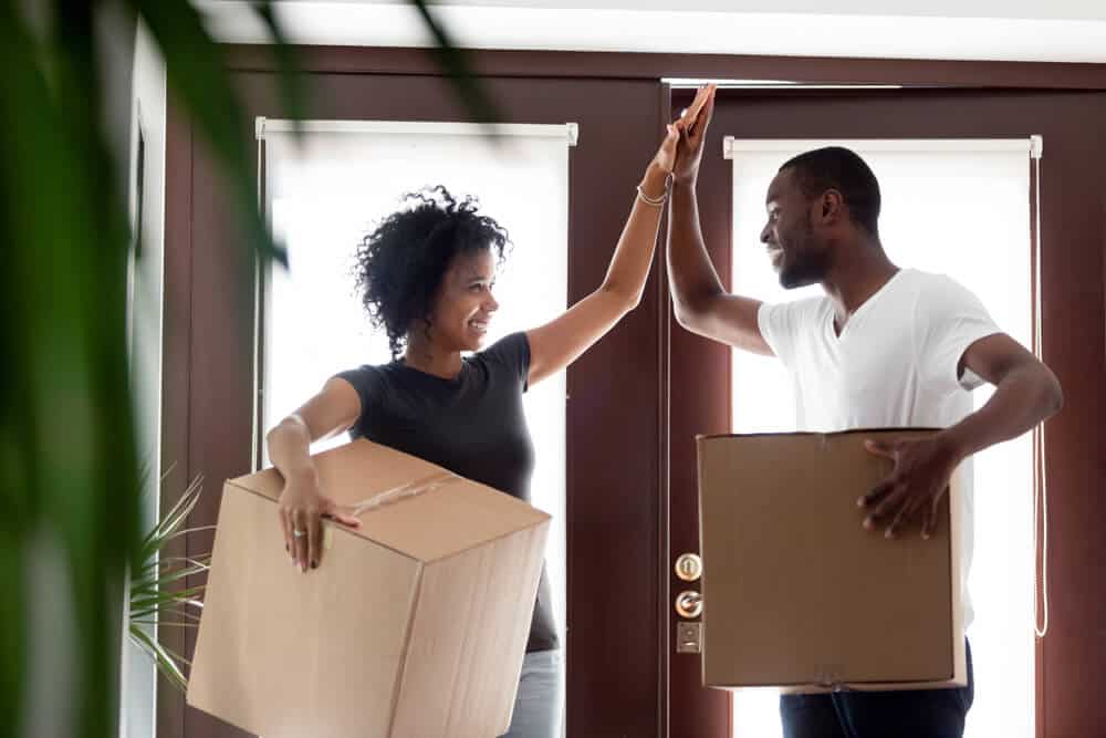 african american couple highfiving with move in boxes
