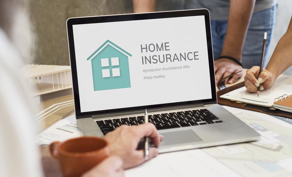 person looking up home insurance on laptop