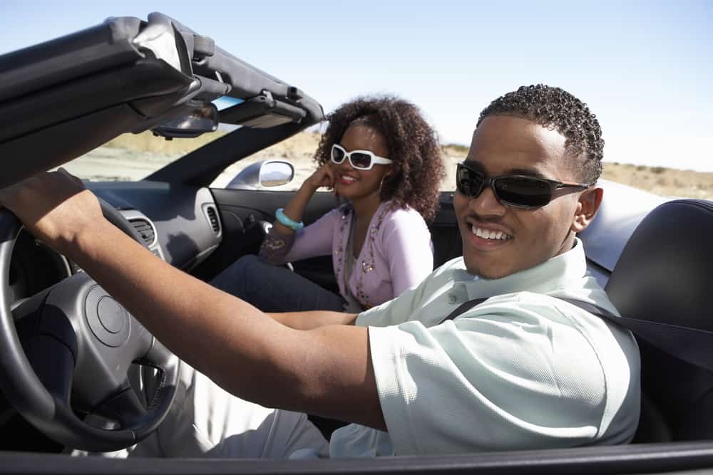 Young African-American couple driving in a convertible