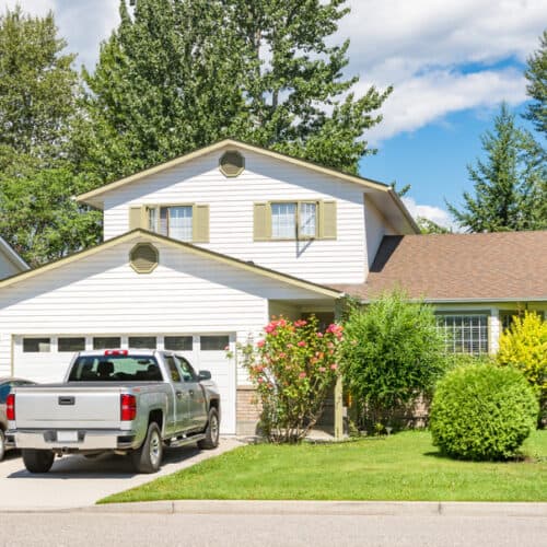 two cars parked in driveway of house