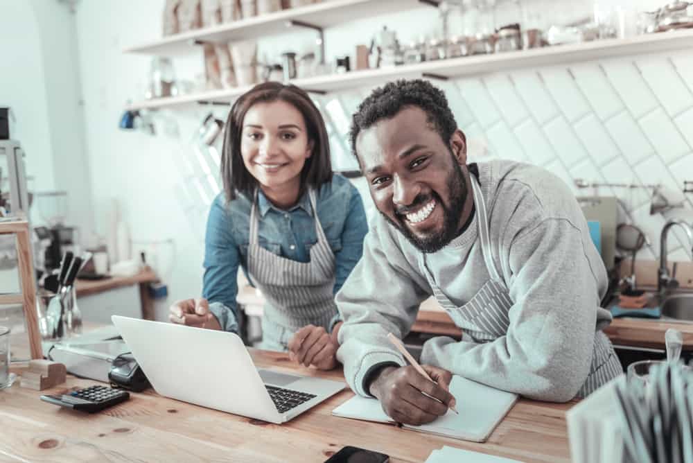 small business owners on computer smiling