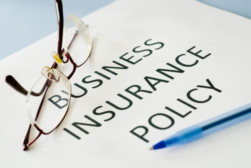 business insurance policy document with glasses