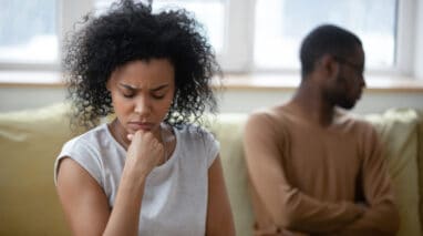 distressed couple sitting on couch