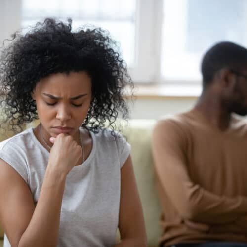 distressed couple sitting on couch