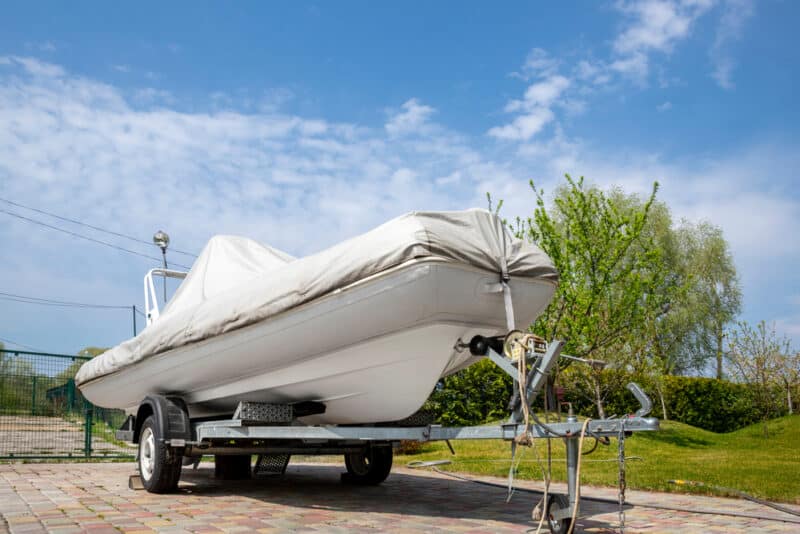 boat on trailer being stored with cover