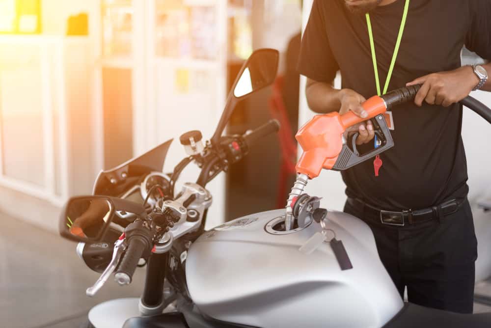 man gassing up motorcycle