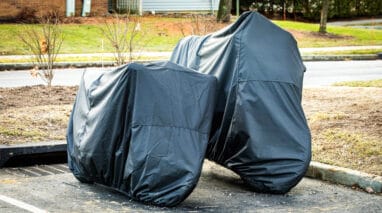 two motorcycle stored under cover in parking lot