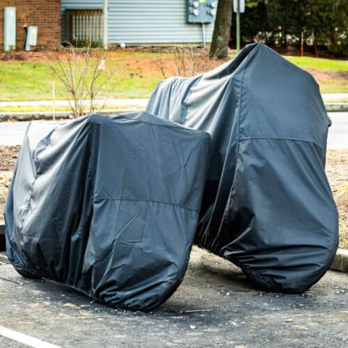 two motorcycle stored under cover in parking lot