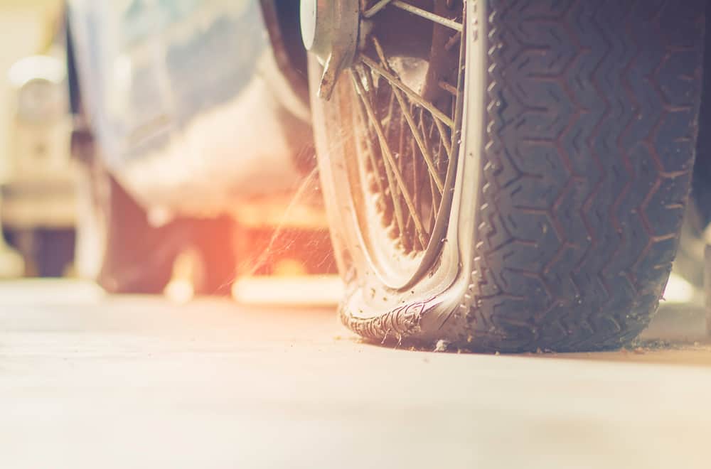 Car stopped with flat tire on front passenger side