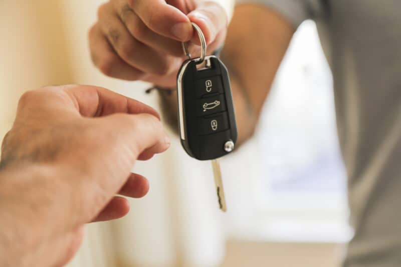 person handing over car keys