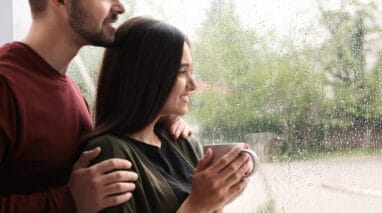 Young couple looks at a window at the rain in Washington
