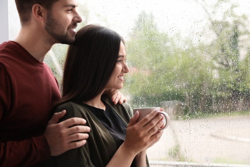 Young couple looks at a window at the rain in Washington