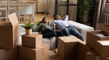 Young couple collapses on couch after moving into new apartment
