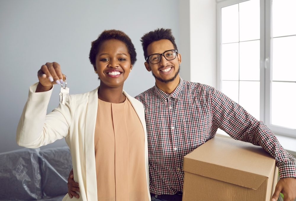 Young African-American Millennial couple holds keys to new apartment
