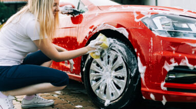 young woman washing her red car in washington