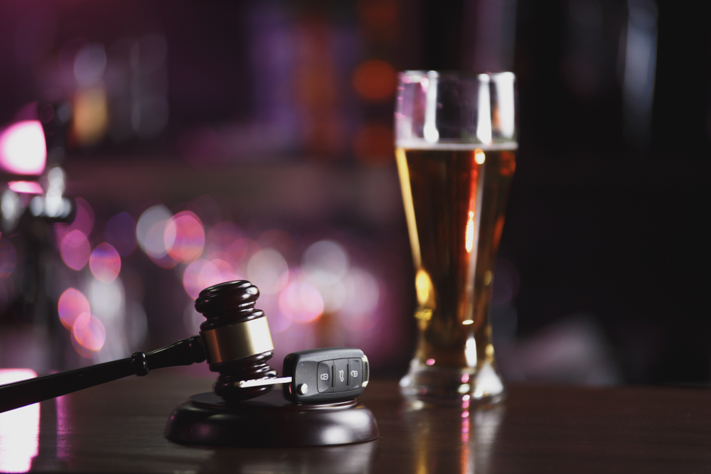 Photo of a glass of beer and, car keys and a gavel