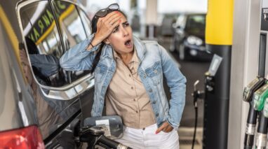 woman stares in horror at gas pump prices