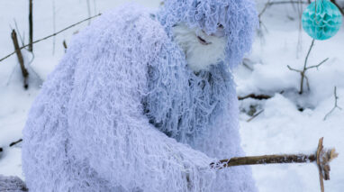 A man pretends to be Sasquatch in the snowy wilderness