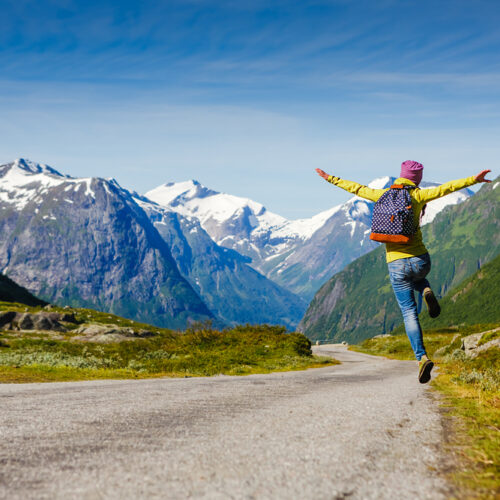 Joyful hiking man jumps in air.