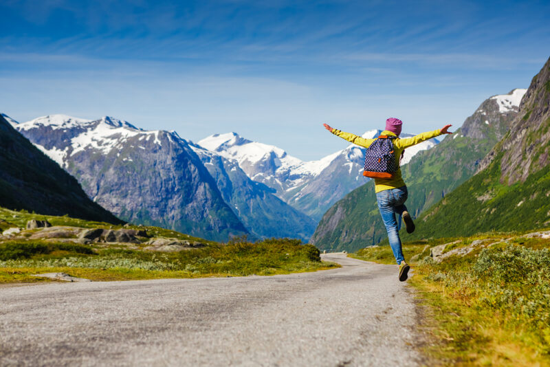 Joyful hiking man jumps in air.