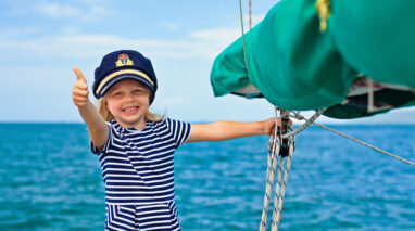 Little girl on a boat wearing the captain's hat - boat insurance in Washington