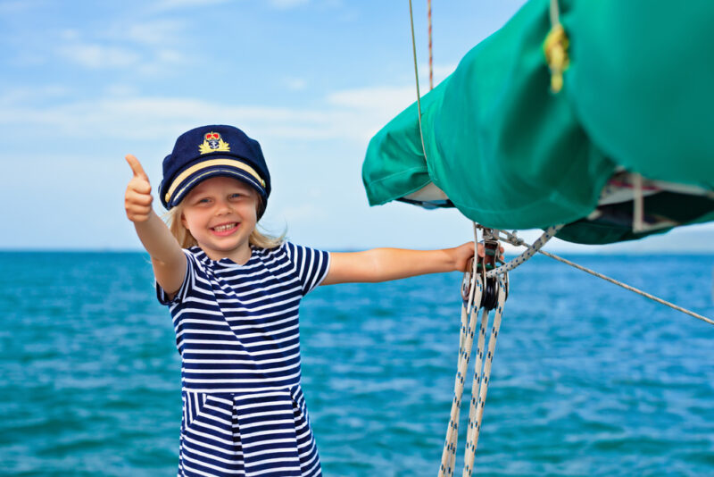 Little girl on a boat wearing the captain's hat - boat insurance in Washington