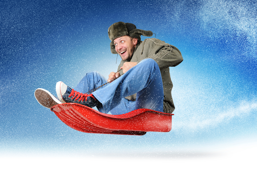 Man flying through snowy weather ona  red sled - cheap snow plow insurance in Washington.