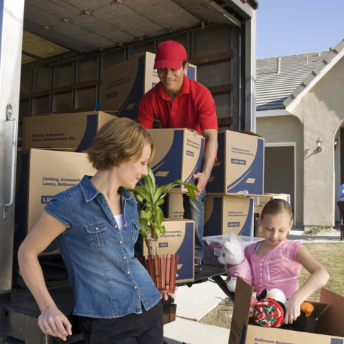 Family loading boxes and furniture in a moving truck, cheap homeowners insurance to protect your move.