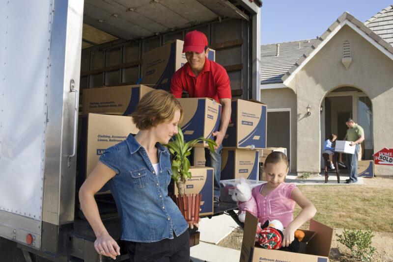 Family loading boxes and furniture in a moving truck, cheap homeowners insurance to protect your move.