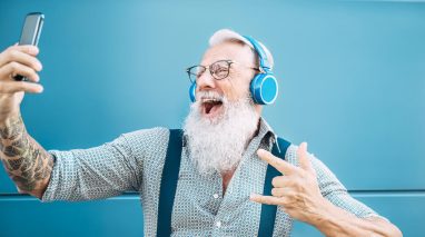 Man with headphones and phone jams out to playlist at the DMV in Washington.