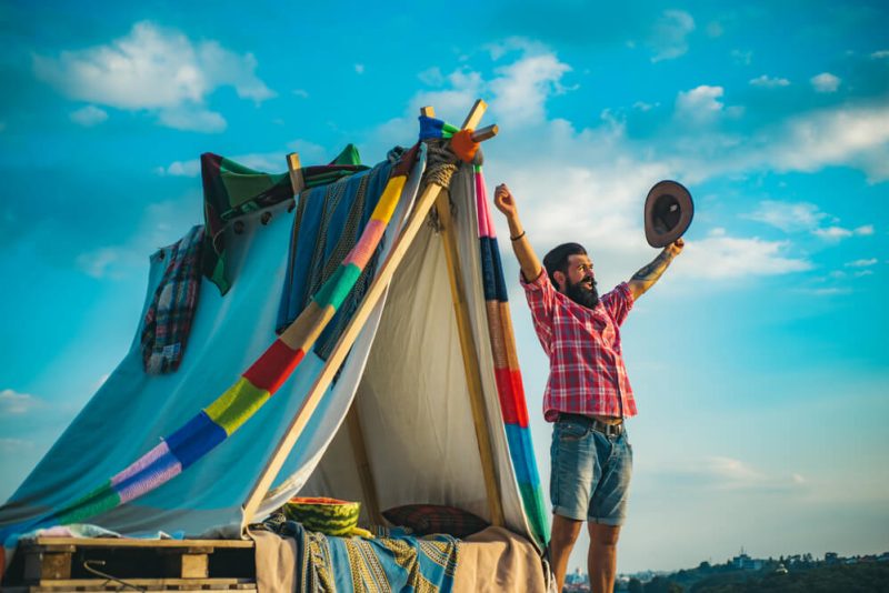 Man celebrates outside of his tent - cheap home insurance in Washington.