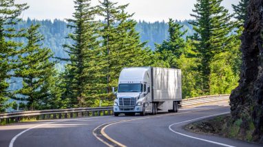 Truck maneuvers through a winding mountain road in Washington State - cheap commercial vehicle insurance.