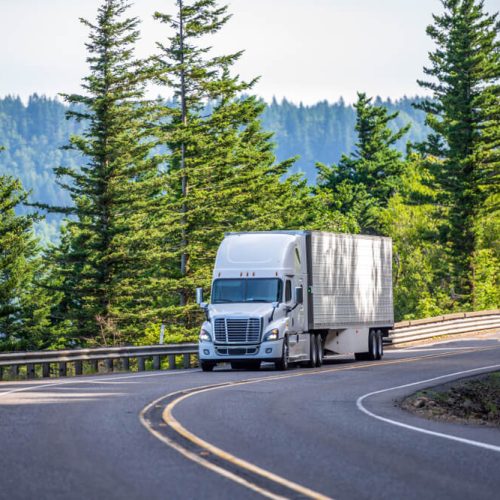 Truck maneuvers through a winding mountain road in Washington State - cheap commercial vehicle insurance.