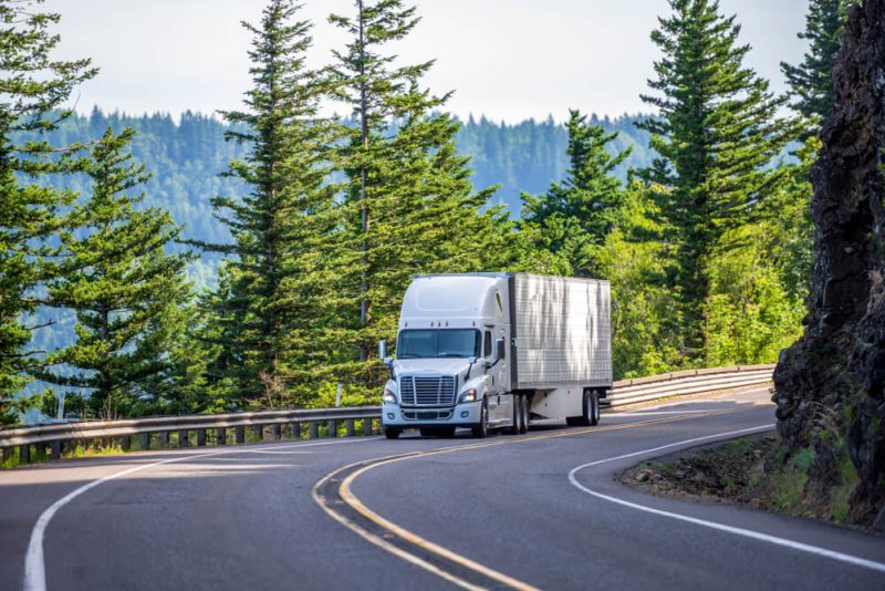 Truck maneuvers through a winding mountain road in Washington State - cheap commercial vehicle insurance.